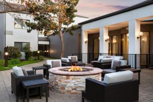 Un patio al aire libre con sillas y una fogata. en Courtyard by Marriott San Francisco Airport, en San Bruno