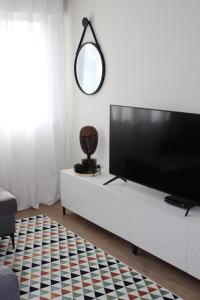 soggiorno con TV a schermo piatto e armadio bianco di Cantinho de Benfica ad Amadora