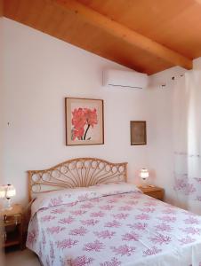 a bedroom with a bed with a floral bedspread at Villa Milena Costa Rei VISTA MARE in Costa Rei