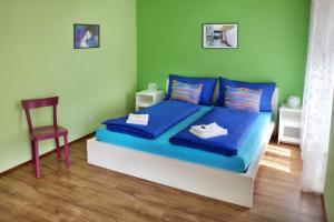 Schlafzimmer mit einem Bett mit blauer Bettwäsche und einem Stuhl in der Unterkunft Ca' di Pincia in Astano