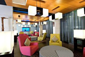 a lobby with colorful chairs and a table at Aloft Bengaluru Whitefield in Bangalore