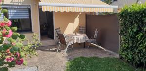 薩爾布呂肯的住宿－Ferienwohnung Dachshübel，坐在院子里伞下的桌子和椅子