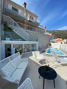 a patio with a couch and chairs and a pool at Villa Ansay with heated Swim Spa pool and sea view in Zaton