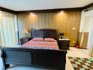 a bedroom with a large bed and wooden walls at Misty Mountain in Murree