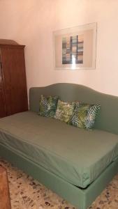 a green couch with pillows in a room at Santa Lucia 4 in Florence