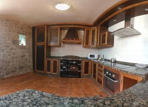 a kitchen with wooden cabinets and a stove at CASA DE LEIS in Leis