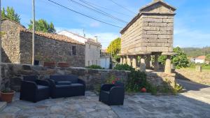 a yard with two chairs and a stone wall at CASA DE LEIS in Leis