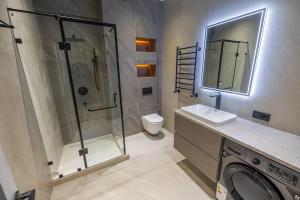 a bathroom with a shower and a sink and a washing machine at Glinka apartment in nukus street in Tashkent