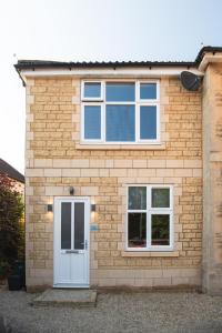 a brick house with a white door and windows at MyCityHaven - The Bathford Annexe in Bath