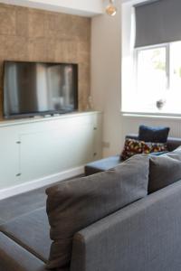 a living room with a couch and a tv at MyCityHaven - The Bathford Annexe in Bath