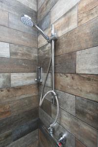 a shower in a bathroom with a wooden wall at MyCityHaven - The Bathford Annexe in Bath