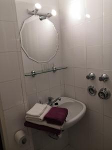 ein Badezimmer mit einem Waschbecken, einem Spiegel und Handtüchern in der Unterkunft Ferienwohnungen Schelhas in Prien am Chiemsee