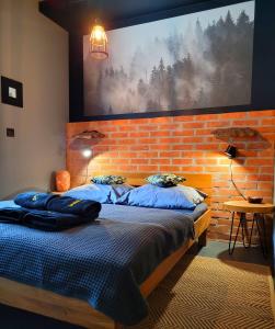 a bedroom with two beds and a brick wall at Apartament SPOKOLOKO Wiślańska Leśny A1 in Szczyrk