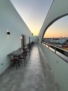 Un balcón con mesas y sillas en un edificio en Rametta Hotel en Montes Claros