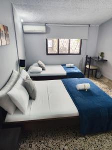 two twin beds in a room with a window at Hotel Loft Dorado in Floridablanca