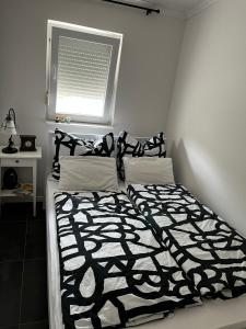 uma cama com um edredão preto e branco e uma janela em HausMamaMia em Vir