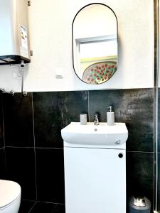 uma casa de banho com um lavatório branco e um espelho. em HausMamaMia em Vir