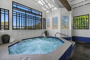 bañera de hidromasaje en una habitación con ventanas en The Wayside Inn, en Cannon Beach