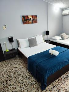 1 dormitorio con 2 camas y manta azul en Hotel Loft Dorado Bucaramanga, en Floridablanca