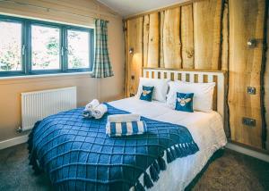 um quarto com uma cama com um edredão azul em The Warrens At Foxtail em Chirk