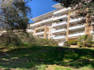 un grand immeuble d'appartements avec une cour devant dans l'établissement CAPO FENO AJACCIO, à Ajaccio