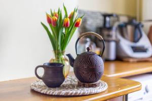 a vase and a tea pot on a counter with flowers at Nordic style room in a quiet residential area in Edinburgh