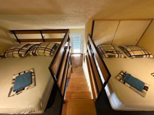 2 Etagenbetten in einem Zimmer mit einer Treppe in der Unterkunft Prizna Apartments in Prizna
