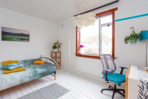 ein Schlafzimmer mit einem Bett, einem Stuhl und einem Fenster in der Unterkunft Nordic style room in a quiet residential area in Edinburgh