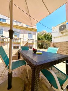 a table with chairs and an umbrella on a patio at Apartment en Rambla in Alicante