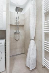 e bagno con doccia con tenda bianca. di L10 Dolce Vita Apartment a Budapest