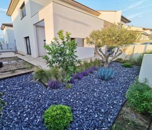 un jardín con rocas y plantas frente a una casa en Villa 4* Bella ciao, entre mer, lac et montagnes en Villeneuve-de-la-Raho