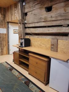 a room with a wooden wall with shelves and a refrigerator at Beaver Creek Ranch in Rothenthurm