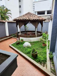 a garden with a gazebo with a fountain at Hotel Loft Dorado in Floridablanca