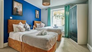 a bedroom with two beds with a cat laying on the bed at Stylish 2 BR in Clifton - Garden in Bristol