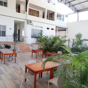 une cour avec des tables et des chaises dans un bâtiment dans l'établissement HOTEL MONTERREY, à Mocoa