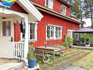 a red house with a picnic table in front of it at 6 person holiday home in VRETA KLOSTER in Vreta Kloster