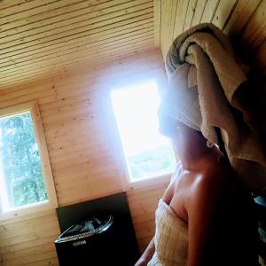 una persona en una habitación en una casa del árbol con ventana en Lila Stuga, en Väja