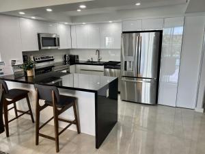 una cucina con frigorifero e armadietti in acciaio inossidabile di Ocean Reserve Condo by FlatsAway a Miami Beach