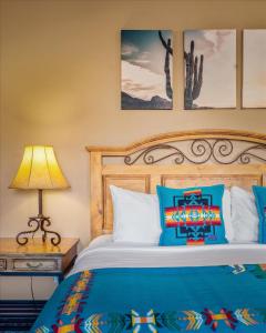 1 dormitorio con 1 cama con sábanas azules y lámpara en Adobe Hacienda, en Sedona