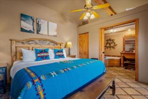 a bedroom with a blue bed and a piano at Adobe Hacienda in Sedona