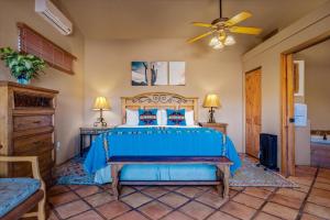 1 dormitorio con 1 cama azul y ventilador de techo en Adobe Hacienda, en Sedona