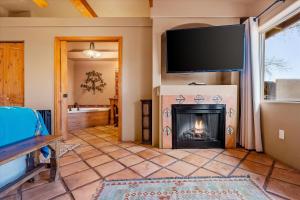 sala de estar con chimenea y TV de pantalla plana en Adobe Hacienda, en Sedona