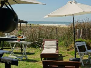 un tavolo con ombrellone e sedia e un tavolo con spiaggia di Carmela Cabo Polonio a Cabo Polonio