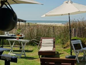 a table with an umbrella and a chair and a table with a beach at Carmela Cabo Polonio in Cabo Polonio