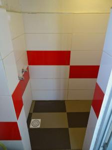 a shower with red white and colorful tiles at Carmela Cabo Polonio in Cabo Polonio