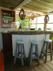un bar al aire libre con dos taburetes verdes delante en Carmela Cabo Polonio en Cabo Polonio