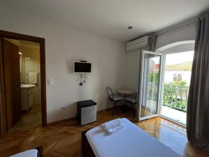 a room with a bed and a balcony with a television at Villa Dante in Trogir