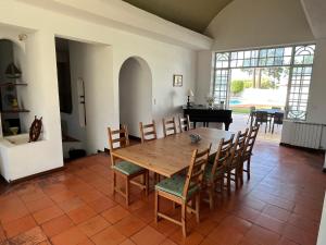 una sala da pranzo con tavolo, sedie e pianoforte di Villa near Beach & Lisbon a Corroios