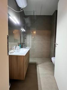 a bathroom with a white sink and a shower at 3E_Apartment_Palase / Villa 149/2 in Palasë