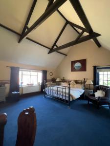 a bedroom with a bed in a room with beams at The Coach House in Retford